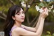 A woman in a purple dress holding a white flower.