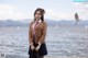 A woman in a school uniform standing by the water.