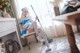 A woman sitting on a chair with a mop in her hand.