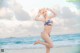 A woman in a bikini standing on a beach.