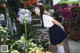 A young woman standing in front of a flower garden.