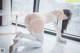 A woman in a white lingerie crouching on the floor.