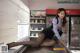 A woman sitting on top of a counter in a store.