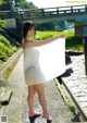 A woman in a white towel standing on a stone path.