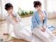 A couple of women sitting on top of a wooden floor.