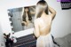 A woman standing in front of a mirror in a bedroom.