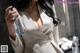A woman in a beige suit holding a bottle of water.